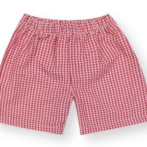 May include: Red and white gingham shorts with an elastic waistband.