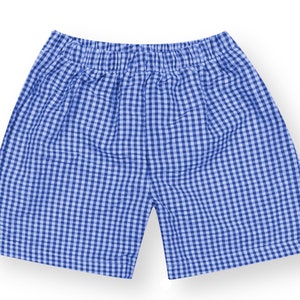 May include: A pair of shorts featuring a blue and white gingham checkered pattern. The shorts have an elasticized waistband and a straight-leg cut, constructed from a lightweight fabric with a consistent grid design throughout the garment.