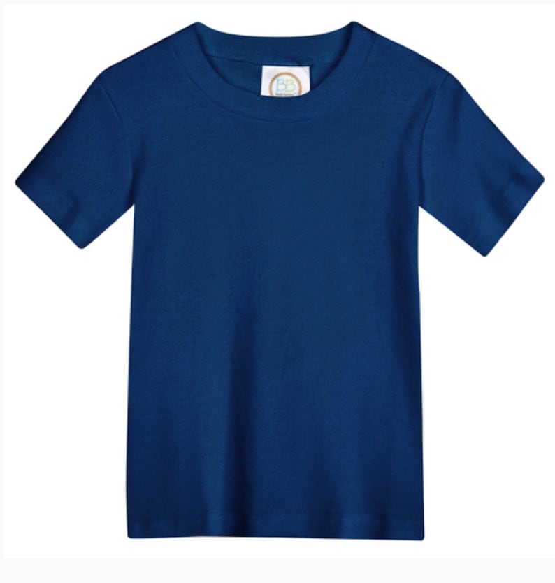 May include: A solid navy blue short-sleeve t-shirt with a crew neckline. The garment features a white interior neck label with the letters BB printed in a circular gold and blue logo design, centered at the inner collar of the plain blue shirt.