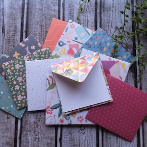 May include: A set of ten colorful patterned envelopes with white interiors. The envelopes are arranged in a pile with the patterned sides facing up. The patterns include floral, geometric, and polka dot designs.