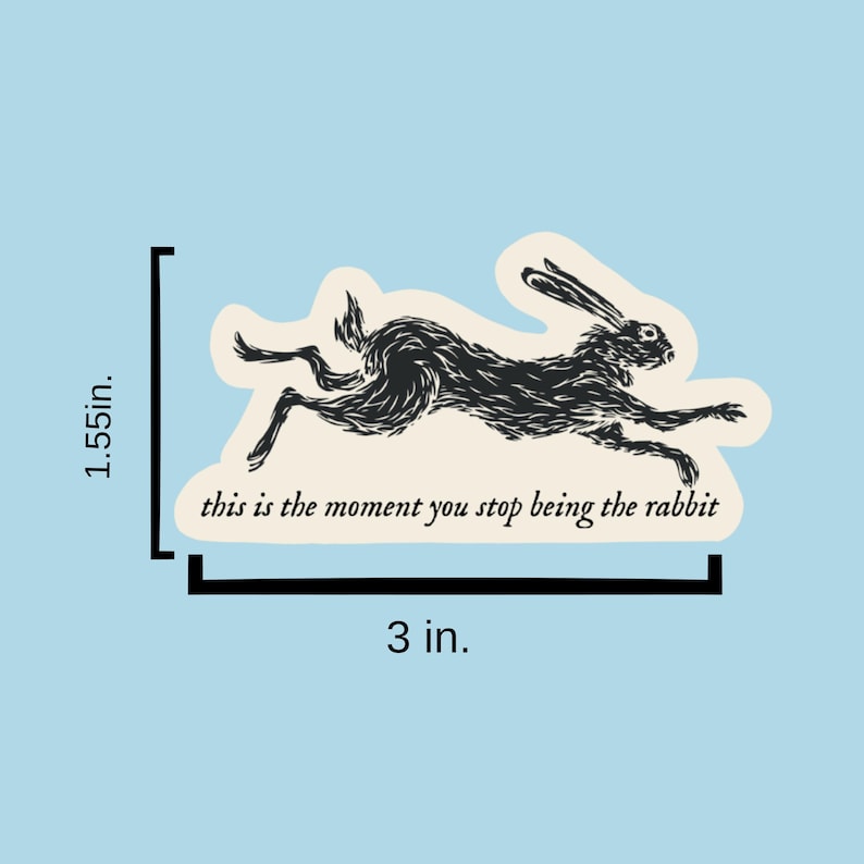 May include: Black and white illustration of a rabbit running with the text "this is the moment you stop being the rabbit" on a white background. The sticker is 3 inches wide and 1.55 inches tall.