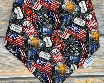 May include: A black bandana with a camouflage pattern featuring American flags, military dog tags, and the words "USMC", "Honor", "Respect", "Courage", and "Marines".
