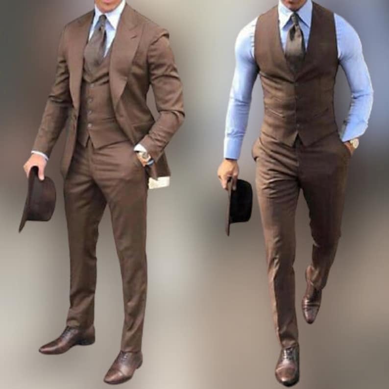 May include: Two men wearing brown three-piece suits with a vest, a jacket, and matching pants. Both men are wearing brown leather shoes and holding a brown fedora hat.