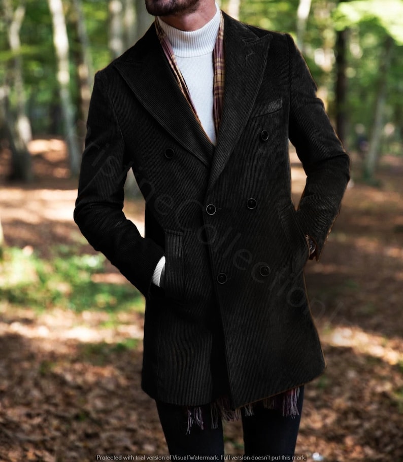 May include: A black corduroy double-breasted coat with a white turtleneck sweater underneath. The coat has a long length and a classic style.