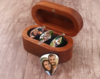 May include: A wooden box with a hinged lid, containing four guitar picks. Each pick has a different photo printed on it, including a couple, a family, and a dog.