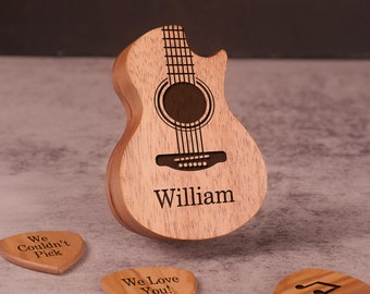 May include: A wooden acoustic guitar with a personalized name "William" engraved on the body. The guitar is surrounded by three wooden guitar picks with engraved messages: "We Couldn't Pick", "We Love You!" and a musical note.