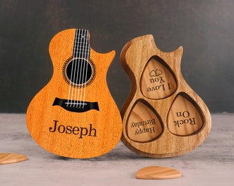 May include: A wooden guitar-shaped pick holder with three slots for guitar picks. The holder has the words "Rock On", "Happy Birthday", and "I Love You" engraved on the picks. A wooden acoustic guitar with the name "Joseph" engraved on it is next to the pick holder.