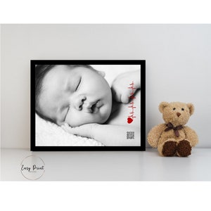 May include: Black and white photo of a sleeping baby with a red heart and heartbeat graphic in the corner.
