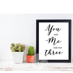 May include: Black and white printable wall art with the text "You and Me and our Three" in a cursive font.
