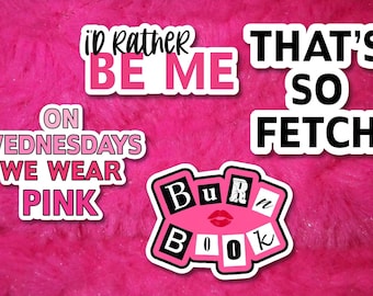 May include: Four vinyl stickers with white borders. The text reads: I'D RATHER BE ME in pink and black, THAT'S SO FETCH in black, ON WEDNESDAYS WE WEAR PINK in pink, and BURN BOOK in black and white with a red lip icon on a pink background.