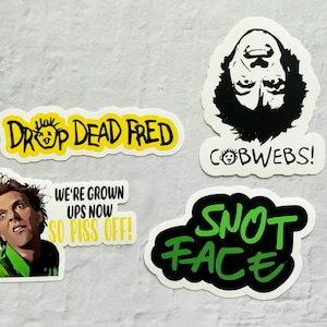 May include: Four stickers featuring a character from the movie 'Drop Dead Fred'. The stickers feature the text 'Drop Dead Fred', 'We're Grown Ups Now So Piss Off!', 'Cobwebs!' and 'Snot Face'.