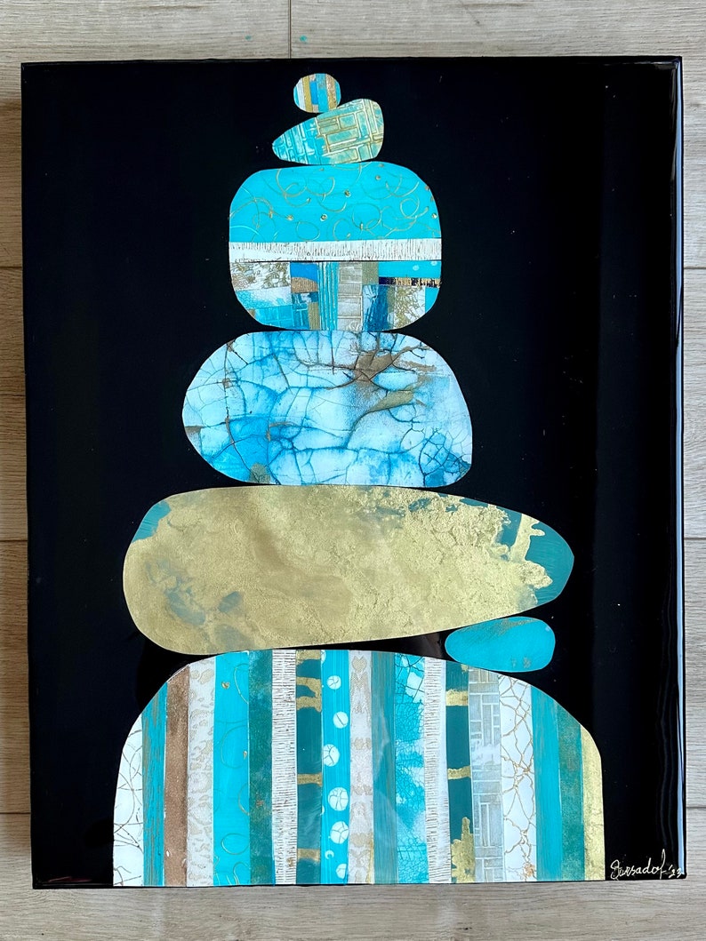 Puede incluir: Pintura abstracta de una pila de piedras azules y doradas sobre un fondo negro. Las piedras est&aacute;n superpuestas y texturizadas, con una variedad de patrones y dise&ntilde;os. La firma del artista es visible en la esquina inferior derecha.