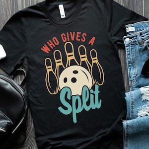 May include: Black t-shirt with a vintage-style graphic of bowling pins and a bowling ball. The text "Who Gives A Split" is written in a retro font.