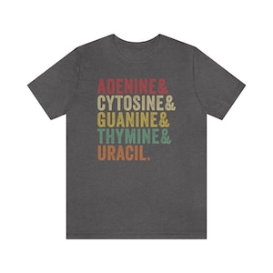 May include: A dark heather grey t-shirt with a vintage-style graphic that reads "Adenine & Cytosine & Guanine & Thymine & Uracil."