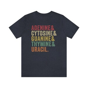 May include: A navy blue t-shirt with a vintage-style graphic that reads "Adenine & Cytosine & Guanine & Thymine & Uracil."