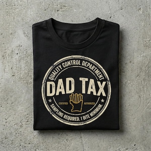 Puede incluir: Camiseta negra con un dise&ntilde;o circular que dice "QUALITY CONTROL DEPARTMENT DAD TAX" en una fuente desgastada. El dise&ntilde;o incluye una ilustraci&oacute;n de patatas fritas y el texto "SAMPLING REQUIRED. 1 BITE MINIMUM."