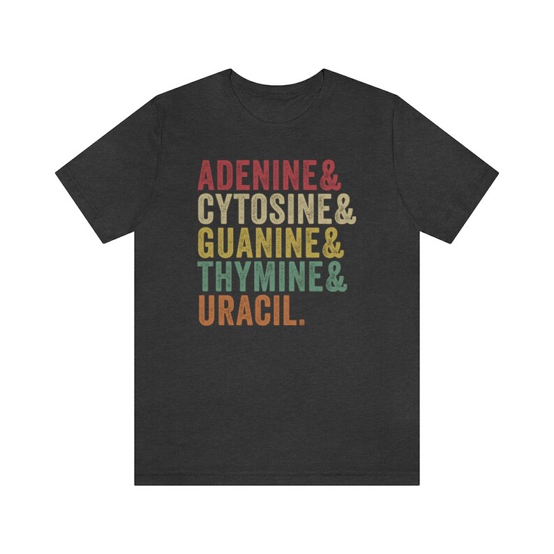 May include: A dark heather grey t-shirt with a vintage-style graphic that reads "Adenine & Cytosine & Guanine & Thymine & Uracil."