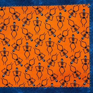 Halloween  Placemats Orange with Tossed Skeletons. Eerie Blue spider web background-set of 4