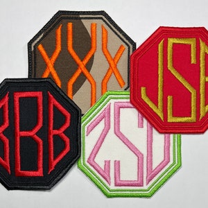 May include: Four octagonal embroidered patches featuring personalized monograms. One patch is black with red letters BBB, one is camouflage with orange XXX, one is red with gold letters JSE, and one is white with pink letters ZSD and a green border.