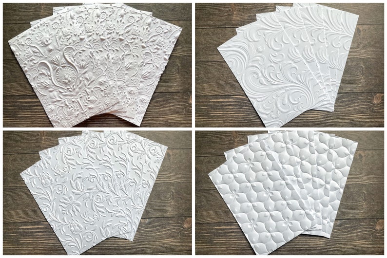 May include: Five white embossed paper sheets with different patterns. The patterns include a floral design, a vine design, and a geometric design.