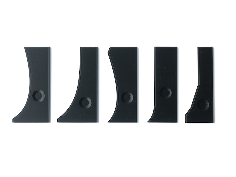 May include: Set of five black plastic shims with rounded edges and a small hole in the center of each shim.