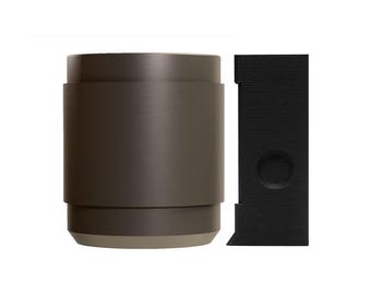May include: An olive-green cylindrical object with a light beige base, positioned next to a black, rectangular item featuring a circular indentation. These items could be components of a larger product, potentially for home decor or design.