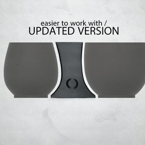 May include: Three grey ceramic cups with a black stand in the centre. The text "easier to work with / UPDATED VERSION" is above the cups.