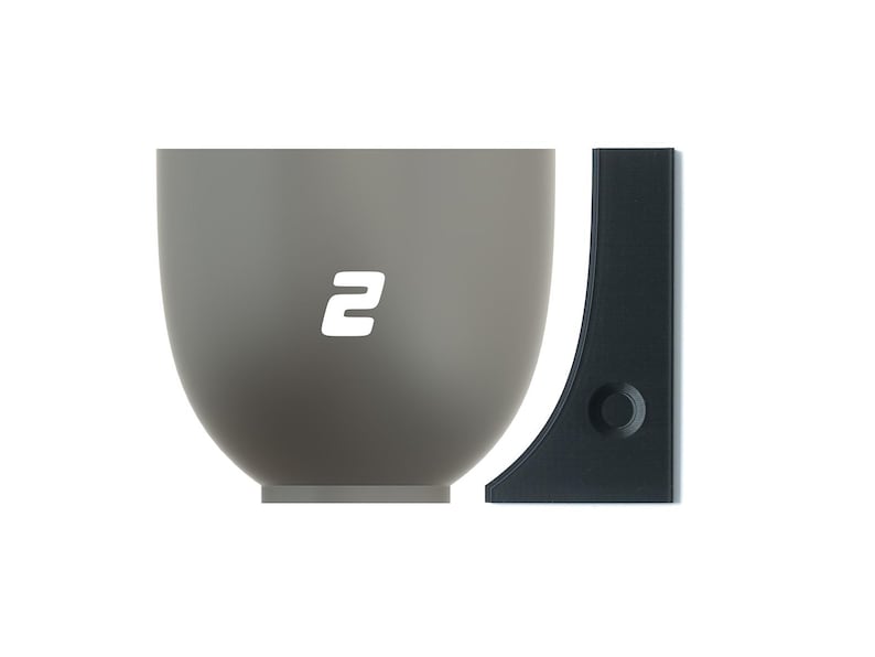 May include: A gray ceramic bowl with a white number "2" on the front. The bowl is next to a black plastic wall mount.