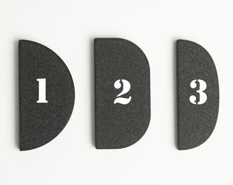 May include: Three black half-circle shaped pieces with white numbers 1, 2, and 3.