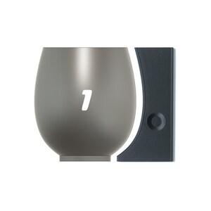 May include: A gray glass vase with a rounded bottom and a number "1" printed on the front. The vase is next to a dark gray rectangular object.