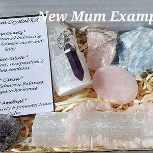 Może przedstawiać: Białe pudełko wypełnione kryształami i kartka z napisem "New Mum Crystal Kit" z opisami kryształów: różowy kwarc, niebieski kalcyt, cytryn i ametyst.