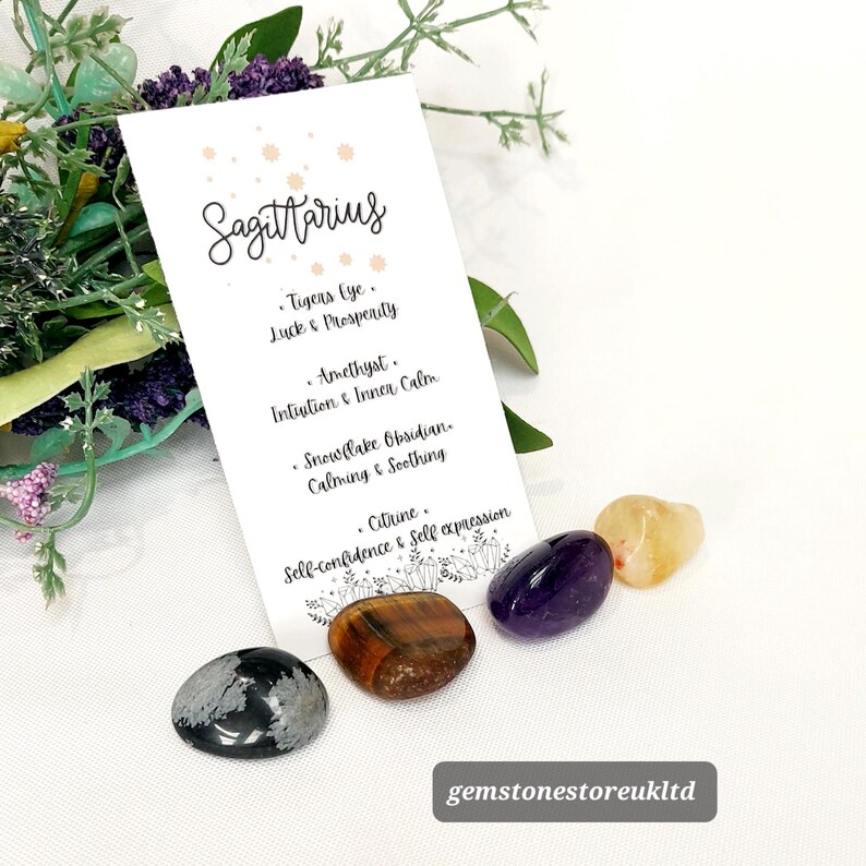May include: A collection of gemstones for the Sagittarius zodiac sign. The image includes a card with the word "Sagittarius" and the names of the stones: Tiger's Eye, Amethyst, Snowflake Obsidian, and Citrine. The gemstones are in shades of brown, purple, and yellow.
