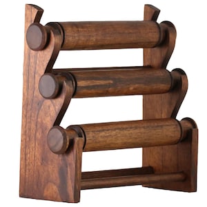 May include: A wooden bangle and bracelet display stand with three rotating rods. The stand is made of dark brown wood and has a simple, rustic design.