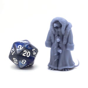 Puede incluir: Un dado azul y blanco de 20 caras con un patrón de espiral negro y una figura en miniatura gris de una criatura que lleva un abrigo blanco con ribete de piel.