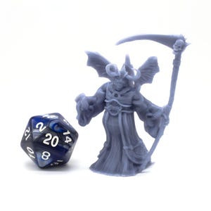 May include: A gray 3D printed miniature of a demon with wings, horns, and a robe holding a scythe. The miniature is standing next to a blue and white 20-sided die.