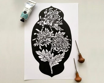 May include: Black and white print of a vase with three chrysanthemum flowers. The vase is outlined in black and the flowers are detailed with intricate lines. The print is on white paper.