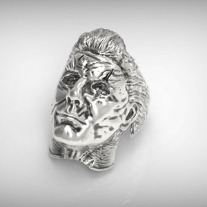 May include: A silver-colored metal sculpture of a man's head with a detailed face and hair.