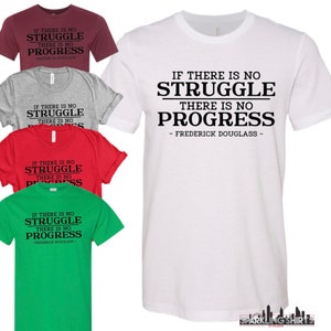 May include: A white t-shirt featuring the quote "IF THERE IS NO STRUGGLE THERE IS NO PROGRESS - FREDERICK DOUGLASS" in black. Other t-shirts in burgundy, grey, red, and green are also visible.