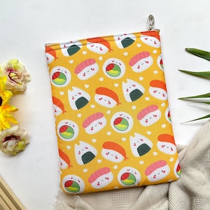 May include: A yellow zippered pouch with a repeating pattern of sushi and onigiri. The sushi and onigiri have cute faces and are surrounded by white hearts.