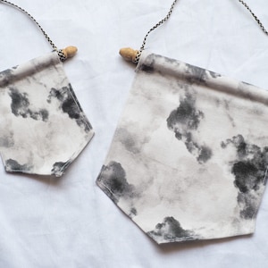 May include: Two fabric banners with a black and white cloud print. The banners are hung with twine and wooden dowels.