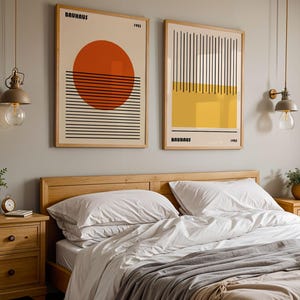 a bedroom with a large bed, wooden nightstands, and two framed abstract artworks hanging on the wall above the bed.