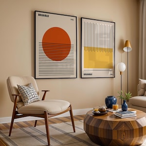a modern living room with a beige sofa, a wooden coffee table, and two framed abstract artworks on the wall.