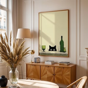Könnte beinhalten: Ein gerahmter Kunstdruck mit einer skurrilen Illustration. Eine schwarze Katze blickt über einen Tisch mit einer grünen Weinflasche, einem Glas und einer Vase. Das Kunstwerk hat einen hellgelben Hintergrund und einen Holzrahmen, für die Inneneinrichtung.