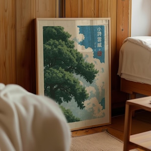 May include: A framed vertical art print featuring a large, dark green pine tree set against a backdrop of light blue sky and white clouds. The artwork includes Japanese text in a vertical column on the right side with a small red square seal below.