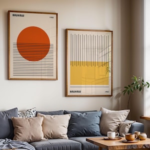 a living room with a blue couch, a coffee table, and two framed abstract artworks hanging on the wall above the couch.