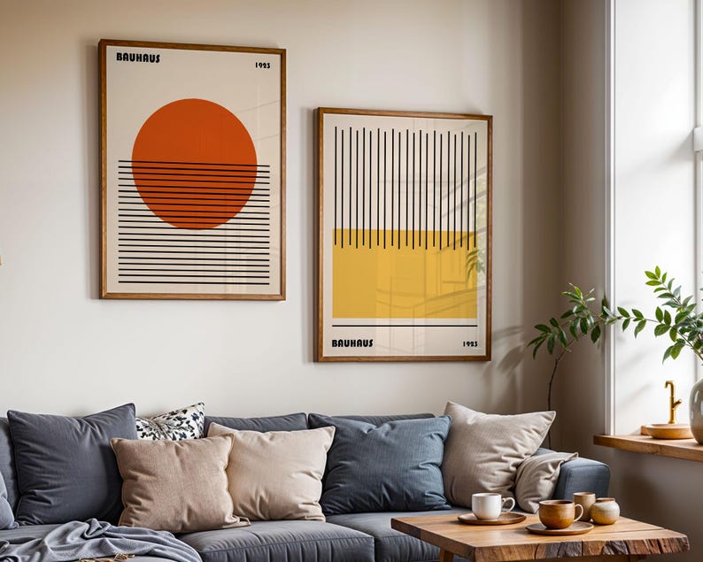 a living room with a blue couch, a coffee table, and two framed abstract artworks hanging on the wall above the couch.