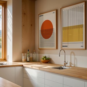a modern kitchen with a wooden countertop, a sink, and two framed abstract artworks hanging on the wall.