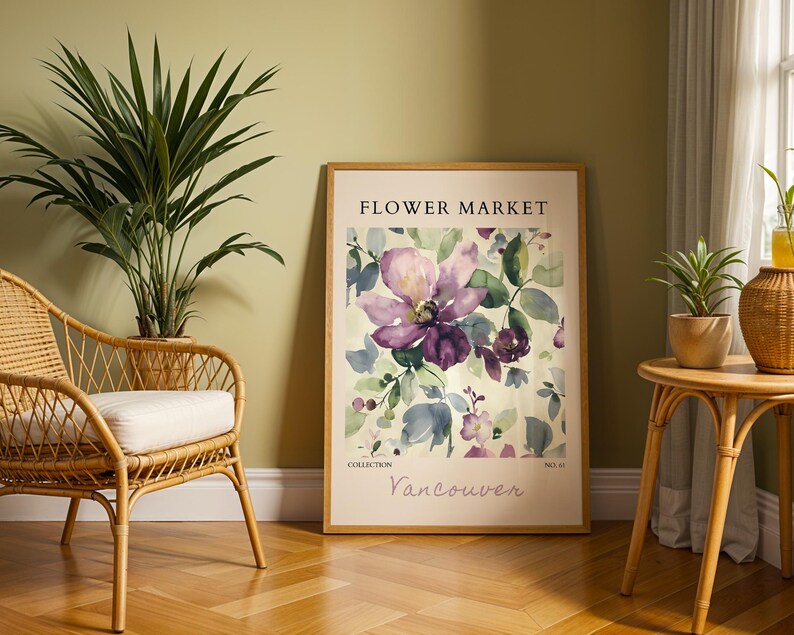 a framed poster of a purple flower on a wall, with a wicker chair and a small table with a plant in the foreground.