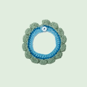 May include: A crocheted collar with a blue and green color scheme. The collar has a white button closure.