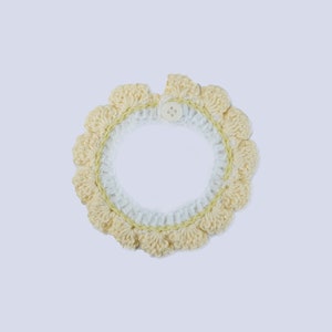 May include: A crocheted collar with a white and yellow design and a single button closure.